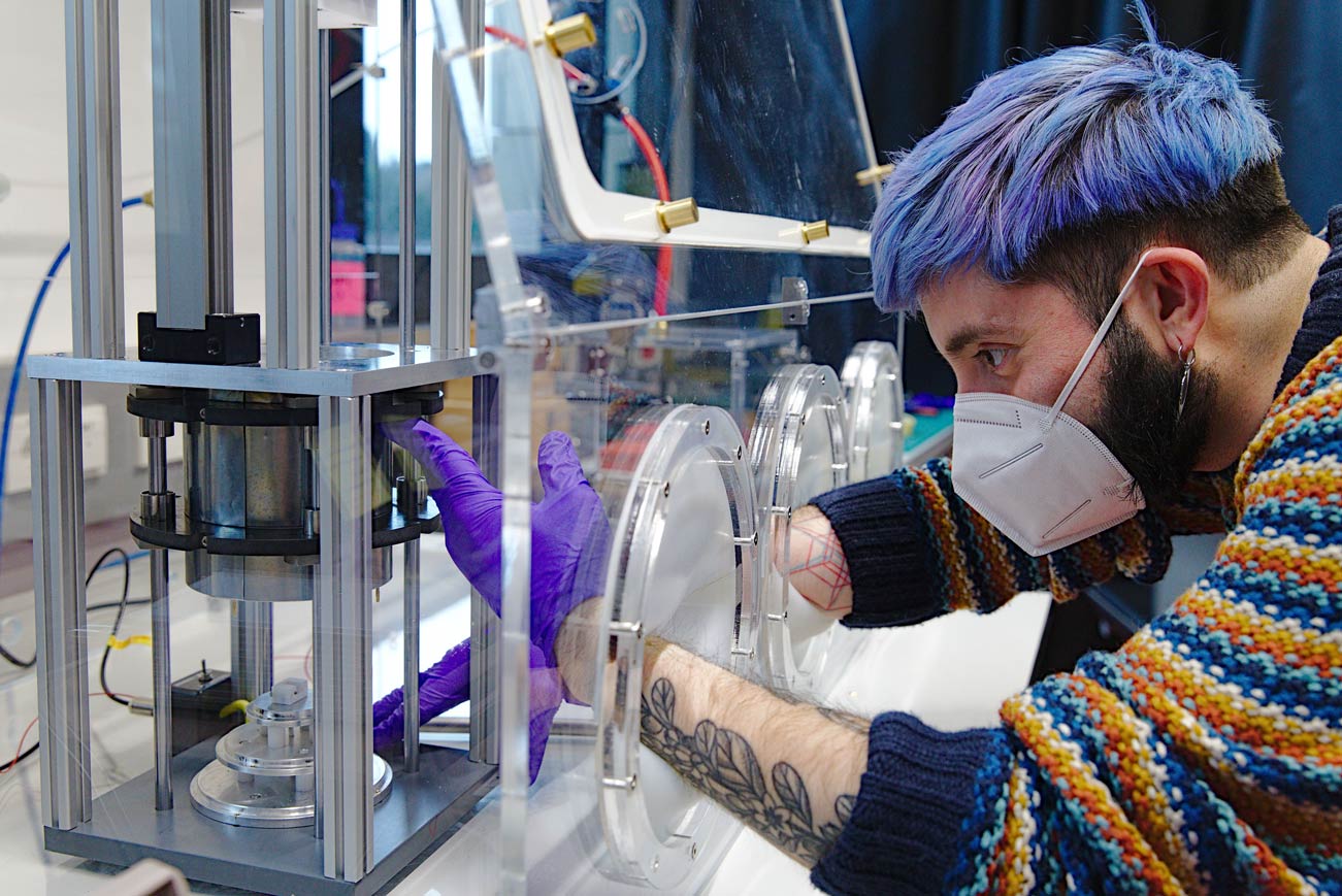 While controlling the humidity in the experimental chamber, PhD student Juan Carlos Sobarzo measures the charge that builds up when two identical surfaces touch. © Nadine Poncioni, IST Austria